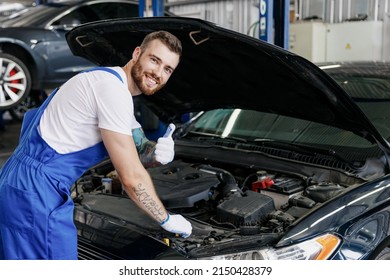 Young professional technician car mechanic man in denim blue overalls white t-shirt gloves fix problem with raised hood show thumb up work in vehicle repair shop workshop indoor Tattoo translate fun - Powered by Shutterstock