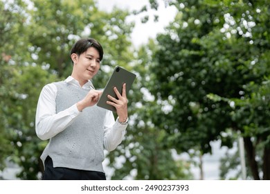 Young Professional Using Tablet Outdoors in Modern Business Environment - Powered by Shutterstock