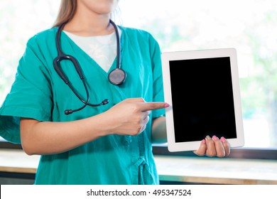 Young And Professional Woman Doctor With An IPad Showing Result Research Something Isolated On Hospital Background.