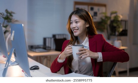 Young professional woman enjoying a coffee break during a late night working session at her modern office - Powered by Shutterstock