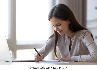 Young Professional Woman Intern Student Noting In Notebook Studying At Home Office, Teen Girl Writing Essay Or Preparing For Test Exam With Laptop, Copywriter Freelancer Making List Planning Tasks