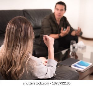 Young Professional Woman Specialist Psychologist Hearing Latin Male Patient In Therapy In Psycology