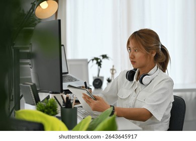 Young Professional woman in tech focused on digital tasks, analyzes code on a computer, working in an office.