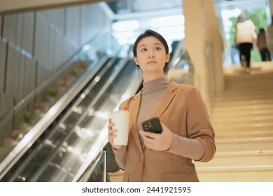 Young Professional Woman Using Phone on Escalator - Powered by Shutterstock