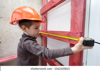 Young professional worker measures the board length with roll tape in helmet