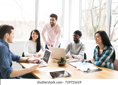 Young professionals working on laptops in an office - Shutterstock ID 719721619