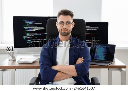 Young programmer working at desk in office