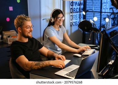 Young programmers working with computer in office at night