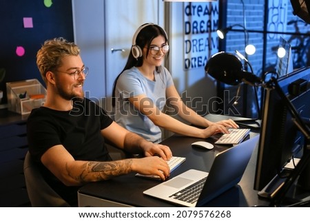 Young programmers working with computer in office at night