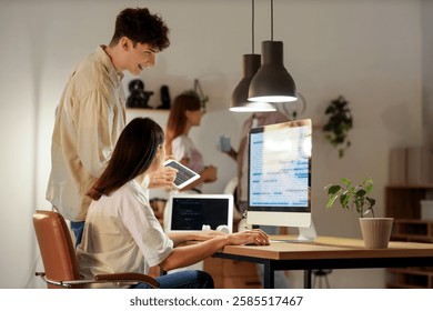 Young programmers working with gadgets in office at night
