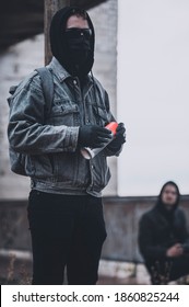 Young protesters group getting ready to make graffiti on the abandoned building. Modern styled urban hooligans.