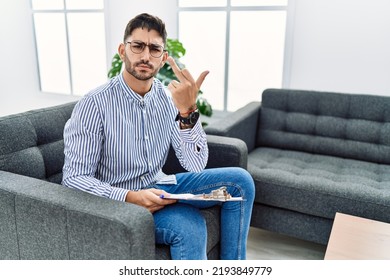 Young Psychologist Man At Consultation Office Showing Middle Finger, Impolite And Rude Fuck Off Expression 