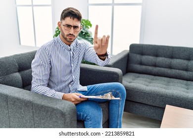 Young Psychologist Man At Consultation Office Pointing With Finger Up And Angry Expression, Showing No Gesture 