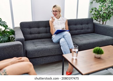 Young Psychologist Woman At Consultation Office Pointing Fingers To Camera With Happy And Funny Face. Good Energy And Vibes. 