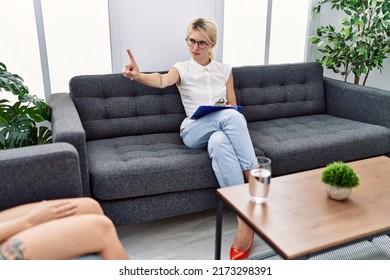 Young Psychologist Woman At Consultation Office Pointing With Finger Up And Angry Expression, Showing No Gesture 