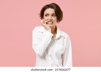 Young Puzzled Confused Troubled Thoughtful Employee Business Woman Corporate Lawyer In Classic Formal White Shirt Work In Office Look Aside Biting Nails Finger Isolated On Pastel Pink Color Background