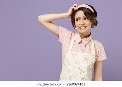 Young Puzzled Displeased Troubled Sad Housewife Housekeeper Chef Cook Baker Woman Wearing Pink Apron Scratch Head Look Aside Isolated On Pastel Violet Background Studio Portrait. Cooking Food Concept.