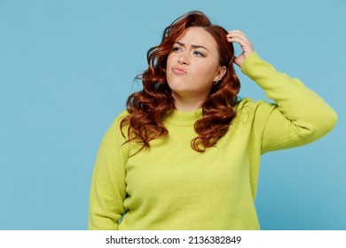 Young puzzled thoughtful confused chubby overweight plus size big fat fit woman wear green sweater look aside scratch head isolated on plain blue background studio portrait. People lifestyle concept - Shutterstock ID 2136382849