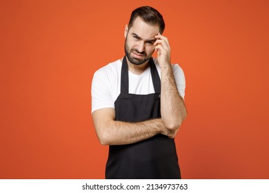 Young Puzzled Troubled Pensive Man 20s Barista Bartender Barman Employee In Black Apron White T-shirt Work In Coffee Prop Up Forehead Head Isolated On Orange Background Studio Small Business Startup