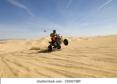 Young Quad Bike Rider Doing Wheelie In Desert