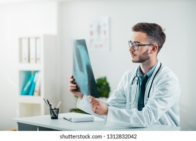 Young Radiologist on the Job looking at x-ray. Volunteer at the hospital gains practical knowledge in treating disease - Shutterstock ID 1312832042