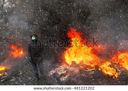 Young rebel calls for a rally against the tyranny of the authorities among the burning of the capital of the European quarter. Burning tires rekolesa from Molotov cocktails, smoke and soot fire