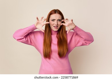 Young red hair woman isolated upset screaming with tense hands. - Shutterstock ID 2258771869