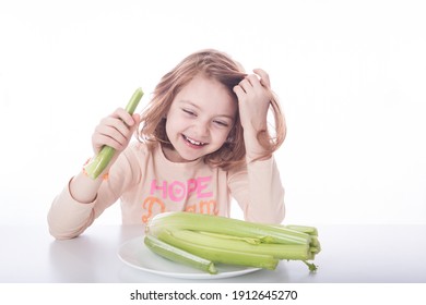 Young Red Haired Girl Laughing While Eating Healthy Celery. White Background With Healthy Food And Happy Child. 