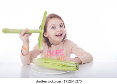 Young Red Haired Girl Laughing While Using Healthy Celery Stick As Chopsticks. White Background With Healthy Food And Happy Child. 