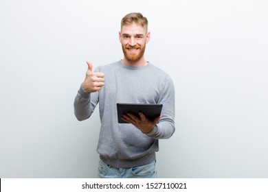 young red head man holding a tablet against white background - Shutterstock ID 1527110021
