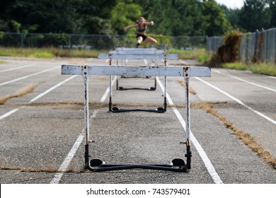 Young Red Headed Girl Practicing Hurdles On Old School Track With Old Hurdles