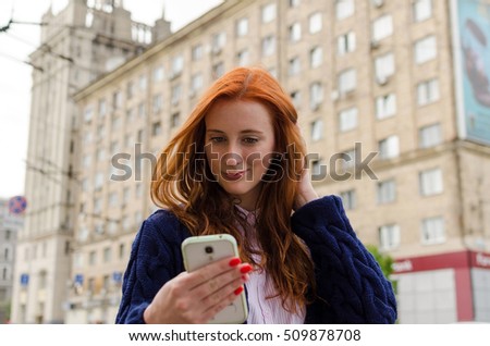 Young red woman making selfie with her cell phone