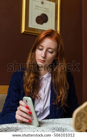 Young red woman using her cell phone 