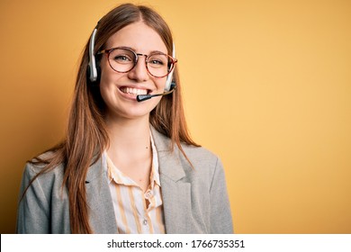 Young redhead call center agent woman overworked wearing glasses using headset with a happy and cool smile on face. Lucky person.