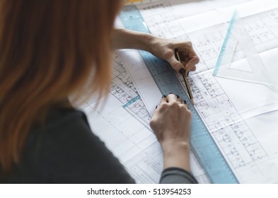 Young Redhead Female Architect Working In Office. Selective Focus And Small Depth Of Field.