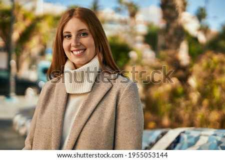 Young redhead girl smiling happy standing at the city.