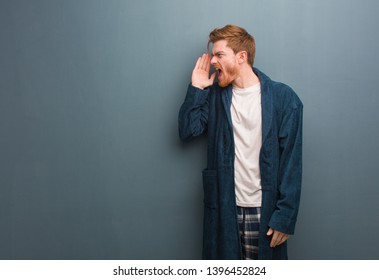 Young redhead man in pajama whispering gossip undertone - Shutterstock ID 1396452824
