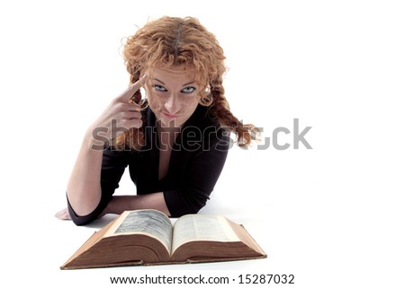 Young redhead reading book, making a funny face