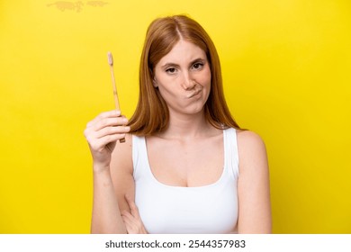 Young redhead woman brushing teeth with sad expression - Powered by Shutterstock