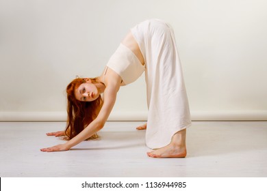 Young Redhead Woman Does Stretching And Yoga Poses, Dancing Contemporary Dance, Posing In Studio, . Copy Space