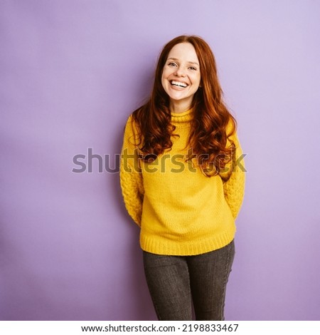 Young redhead woman laughs at camera