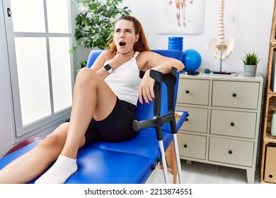 Young Redhead Woman Lying On Rehabilitation Bed Holding Crutches Touching Painful Neck, Sore Throat For Flu, Clod And Infection 