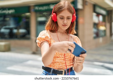 Young Redhead Woman Playing Video Game At Street