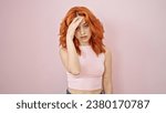 Young redhead woman stressed standing over isolated pink background