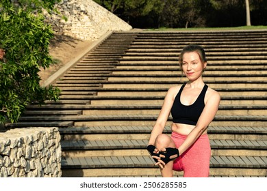 A young redhead woman stretching her legs while practicing yoga and Pilates in a natural setting in the sunshine. - Powered by Shutterstock