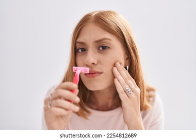 Young redhead woman using razor on moustache at bedroom - Shutterstock ID 2254812689