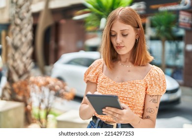 Young Redhead Woman Using Touchpad At Street