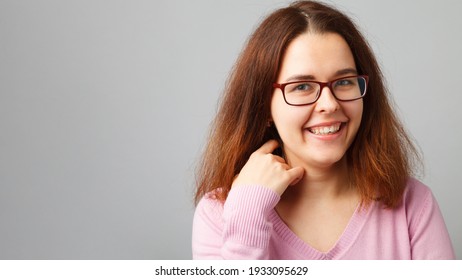 Junge Rotkopffrau mit Brille. Kopf-und Schulterporträt.