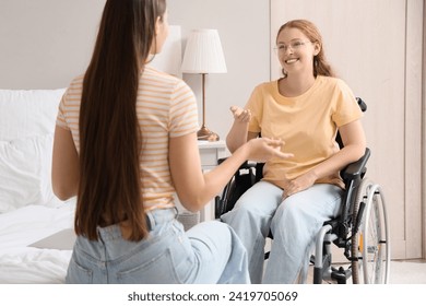 Young redhead woman in wheelchair talking with her friend at home - Powered by Shutterstock