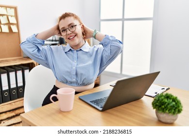 Young Redhead Woman Working At The Office Using Computer Laptop Relaxing And Stretching, Arms And Hands Behind Head And Neck Smiling Happy 